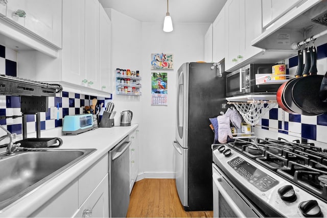 30 Bogardus Pl Unit 2B, New York City, NY 10040 - kitchen with appliances with stainless steel finishes, decorative backsplash, light wood-style flooring, white cabinetry, and light countertops