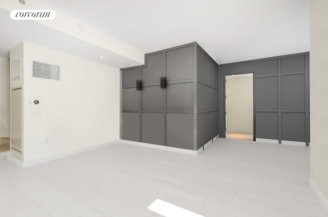 959 1st Ave Unit 6G, New York City, NY 10022 - unfurnished room featuring baseboards, a decorative wall, and light wood-type flooring