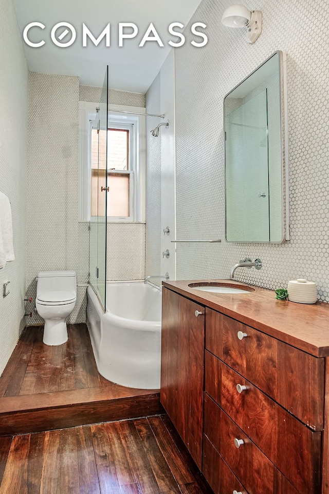 391/2 Washington Sq S Unit 9, New York City, NY 10012 - full bathroom with hardwood / wood-style flooring, toilet, shower / tub combination, and vanity