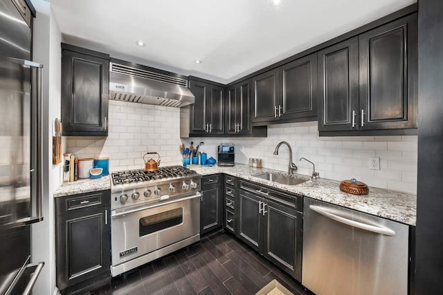 207 E 74th St Unit 7F, New York City, NY 10021 - kitchen with high end appliances, extractor fan, a sink, dark cabinetry, and recessed lighting