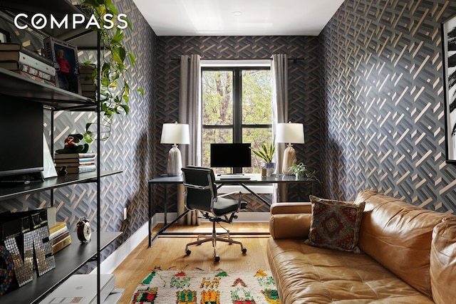 office space featuring wood finished floors and wallpapered walls