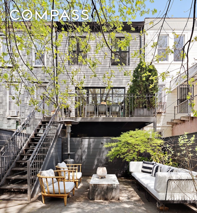 back of property featuring stairs, an outdoor living space, and a patio area