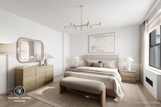 bedroom featuring light wood-style floors and a chandelier