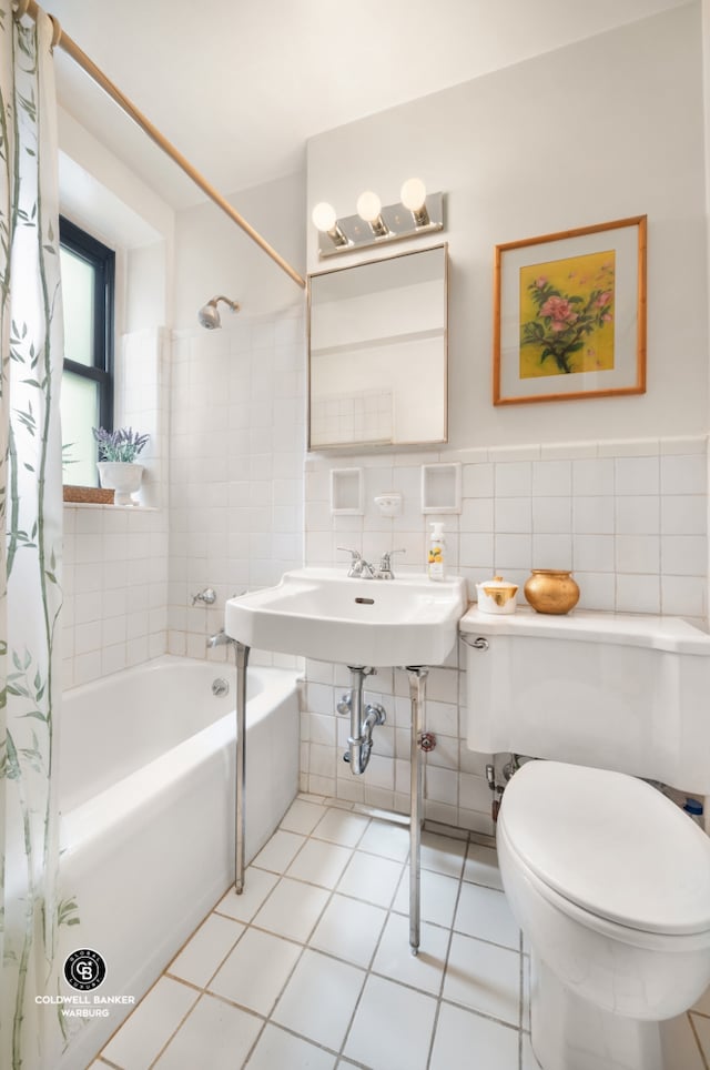 full bathroom featuring tile walls, shower / bath combo, toilet, tile patterned floors, and a sink