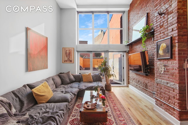 66 N 1st St Unit 1C, New York City, NY 11249 - living area with brick wall, wood finished floors, and a high ceiling