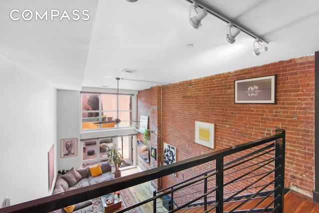 66 N 1st St Unit 1C, New York City, NY 11249 - corridor with wood finished floors, rail lighting, and brick wall