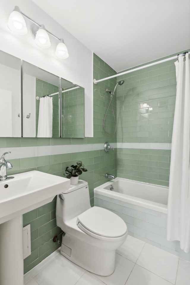61 W 62nd St Unit 8B, New York City, NY 10023 - full bathroom featuring tiled shower / bath combo, tile patterned floors, toilet, tile walls, and a sink