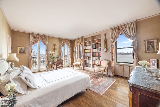 bedroom featuring access to outside, wood finished floors, and multiple windows