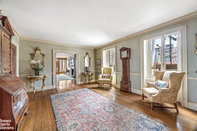 sitting room with hardwood / wood-style flooring and ornamental molding