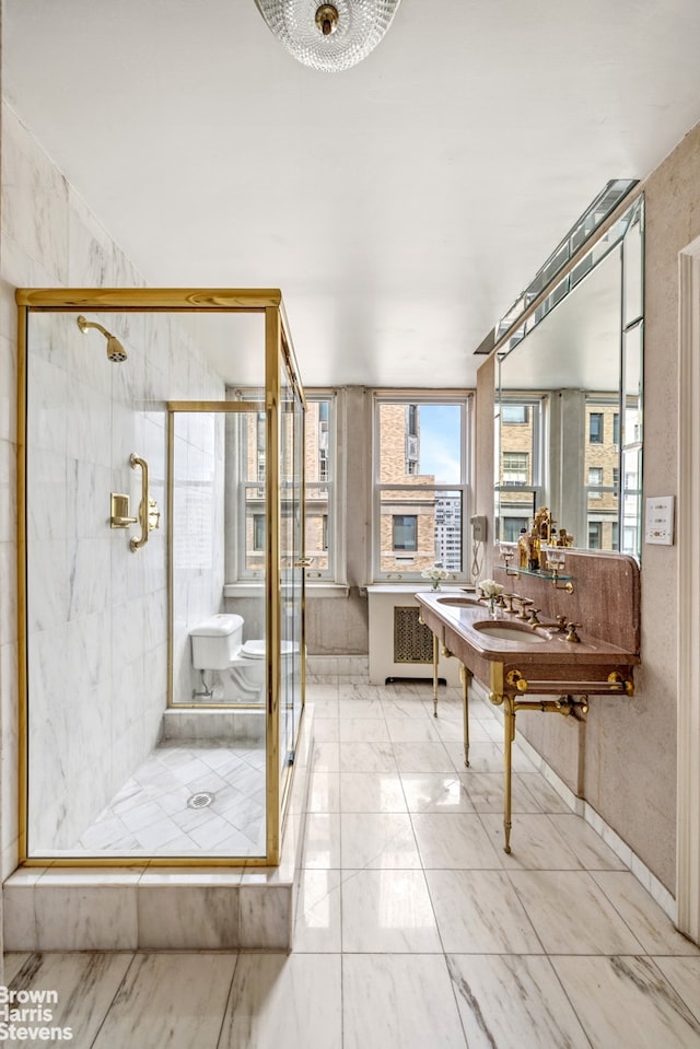 bathroom with plenty of natural light, a stall shower, and marble finish floors