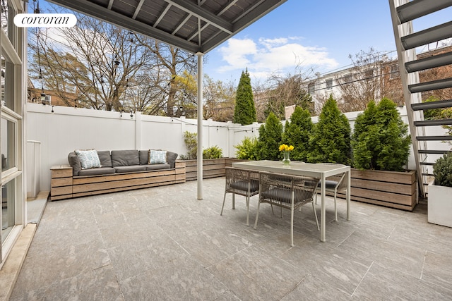 view of patio with a fenced backyard, outdoor dining space, and an outdoor living space