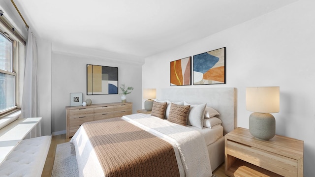 bedroom with multiple windows and light wood-style flooring