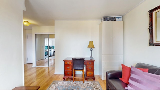 office area featuring light wood-type flooring and crown molding
