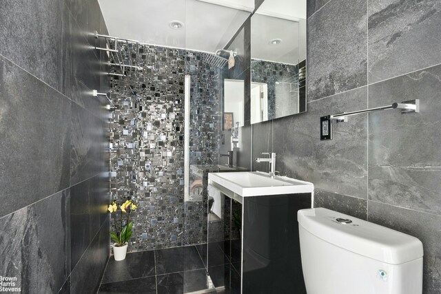 1020 Grand Concourse Unit 9T, New York City, NY 10451 - bathroom featuring walk in shower, toilet, a sink, and tile walls