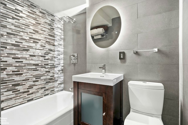 bathroom with toilet, a bathtub, vanity, tile walls, and a shower