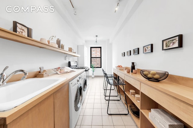 washroom featuring a sink, light tile patterned floors, separate washer and dryer, and track lighting