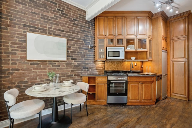kitchen featuring dark countertops, dark wood-style floors, brown cabinets, a sink, and stainless steel appliances