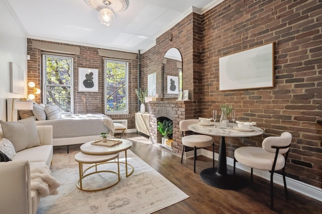 bedroom featuring ornamental molding, wood finished floors, brick wall, and a fireplace