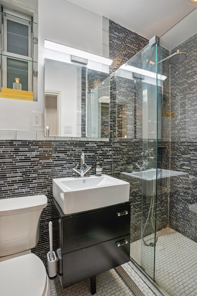 bathroom featuring tile walls, a shower stall, vanity, tile patterned floors, and toilet