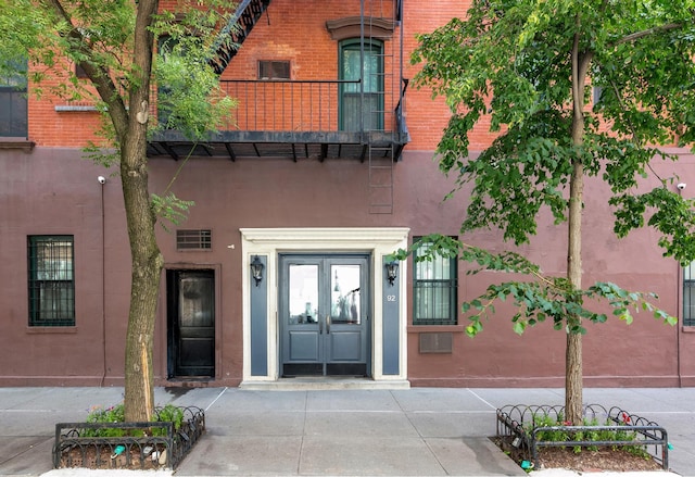 view of exterior entry with brick siding and french doors