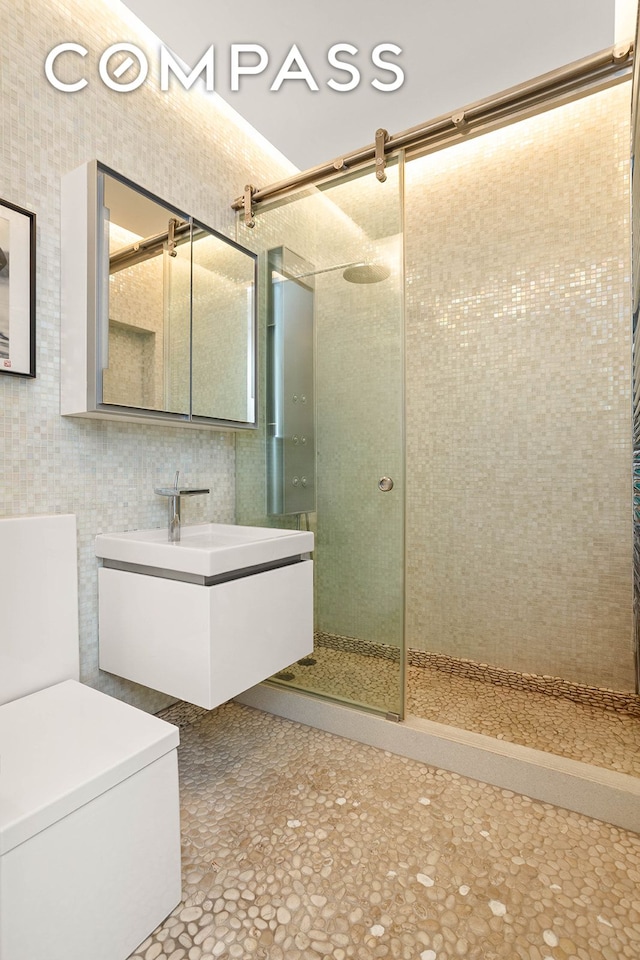244 W 23rd St Unit 3A, New York City, NY 10011 - bathroom featuring a tile shower, vanity, tile walls, and toilet