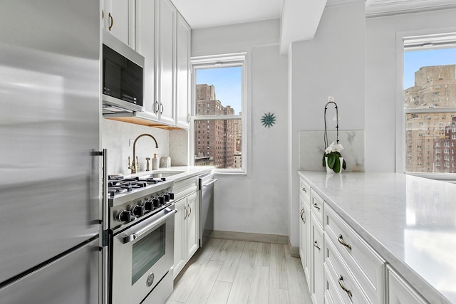 kitchen with white cabinetry, appliances with stainless steel finishes, and a sink