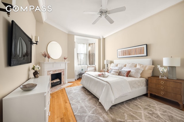 530 W End Ave Unit 9B, New York City, NY 10024 - bedroom with crown molding, light wood finished floors, a fireplace, ceiling fan, and baseboards