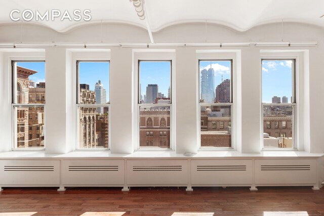 unfurnished sunroom with plenty of natural light and a city view