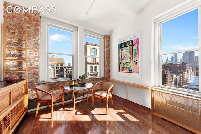 living area with a view of city, plenty of natural light, and hardwood / wood-style flooring