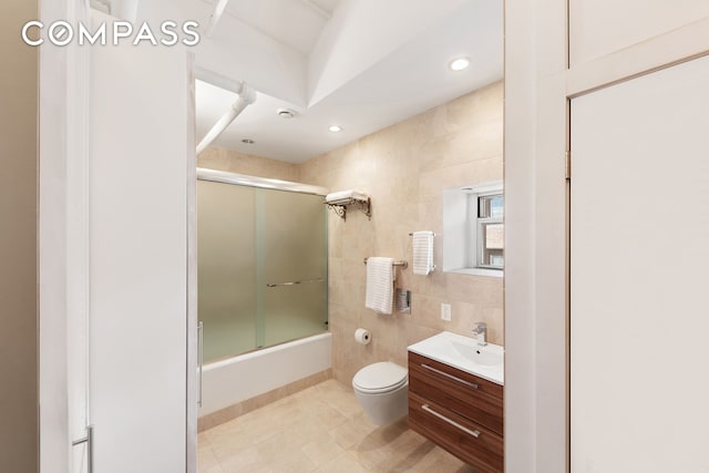 543 Broadway Ph Ph, New York City, NY 10012 - bathroom with tile walls, toilet, vanity, combined bath / shower with glass door, and tile patterned floors
