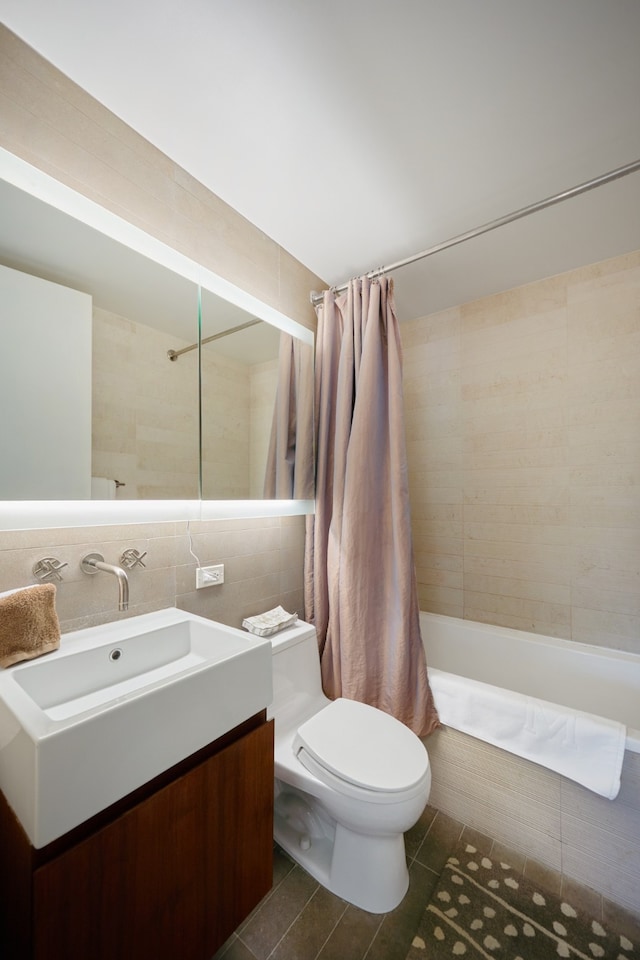 bathroom featuring tile walls, toilet, tile patterned floors, shower / bath combo, and vanity