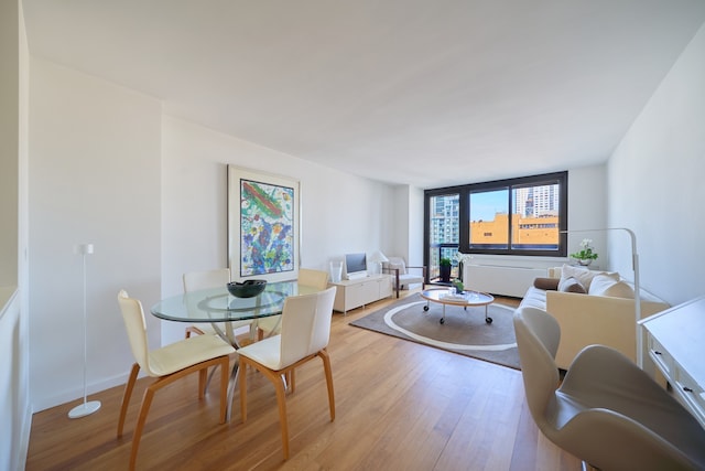 dining room featuring light wood finished floors and baseboards