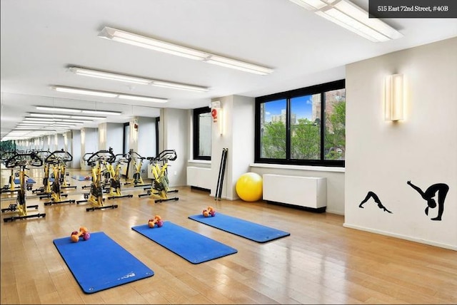 exercise room featuring wood finished floors and baseboards