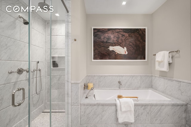 bathroom with a shower stall and a garden tub