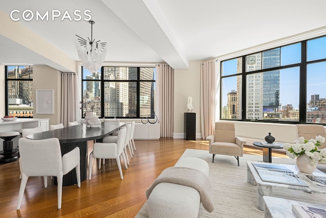 living area featuring baseboards, plenty of natural light, a city view, and wood finished floors