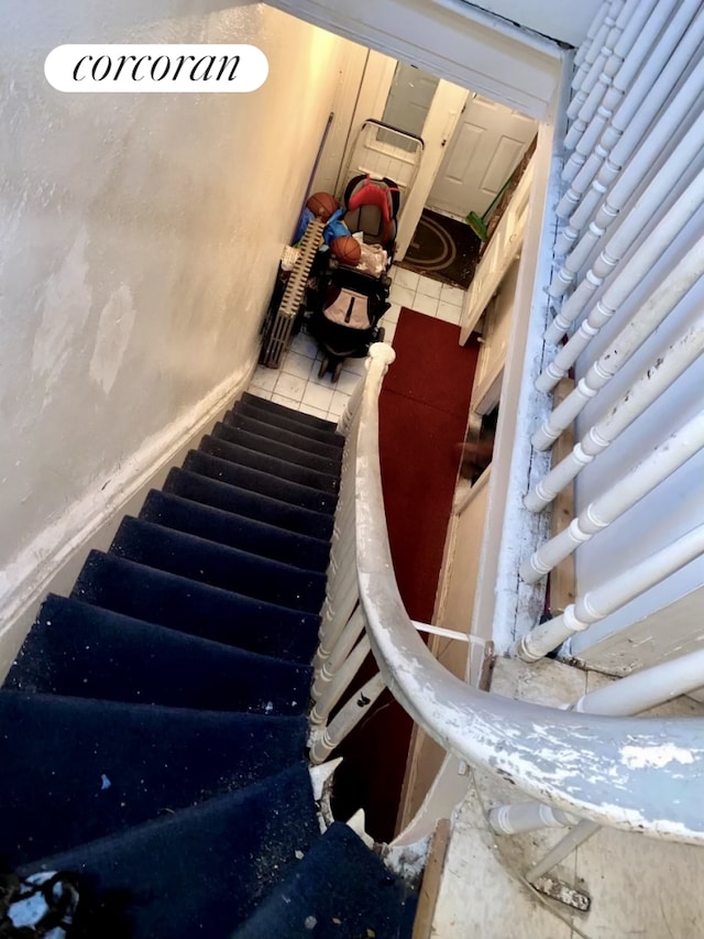 staircase featuring tile patterned flooring