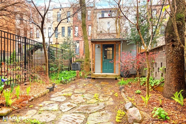 view of exterior entry with fence and central air condition unit