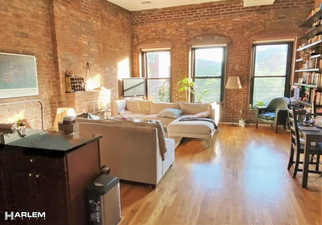 living room featuring wood finished floors and brick wall