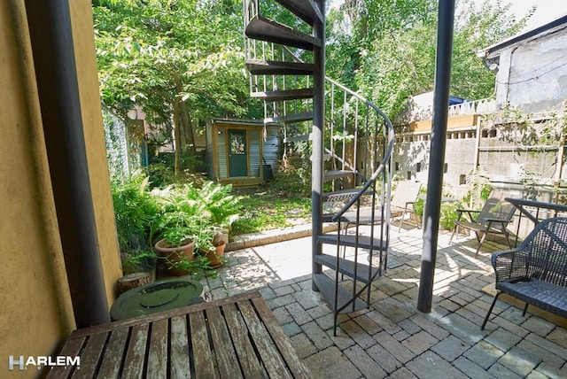 view of patio featuring fence and stairway
