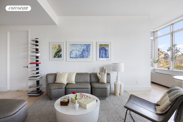 living area with baseboards and light wood finished floors