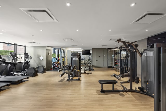 exercise room featuring recessed lighting and light wood-style floors