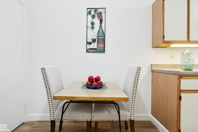 dining room featuring wood finished floors and baseboards