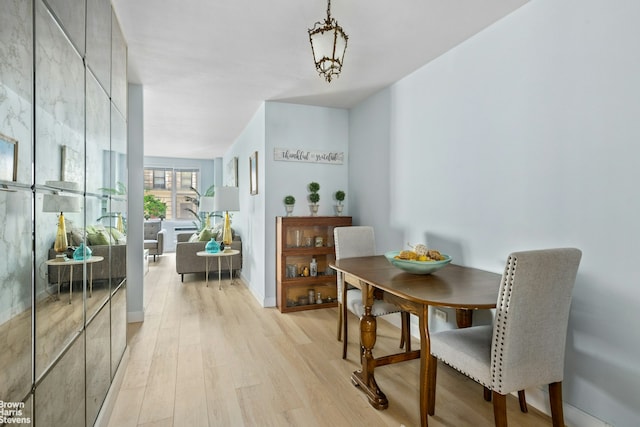 dining room with light wood-style flooring and baseboards