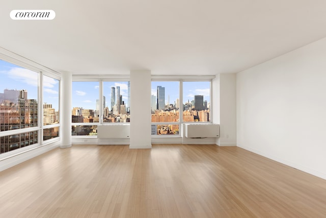 450 W 17th St Unit 2408, New York City, NY 10011 - spare room with a view of skyline and light wood-style floors