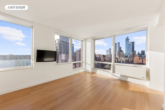 450 W 17th St Unit 2408, New York City, NY 10011 - unfurnished living room with light wood-style flooring and baseboards