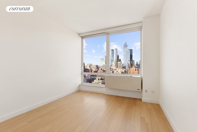 450 W 17th St Unit 2408, New York City, NY 10011 - spare room with light wood-style flooring and a skyline view