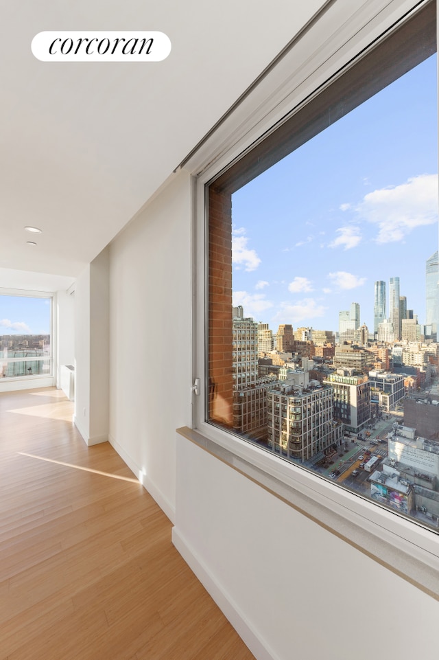 450 W 17th St Unit 2408, New York City, NY 10011 - hall with wood finished floors, baseboards, and a skyline view