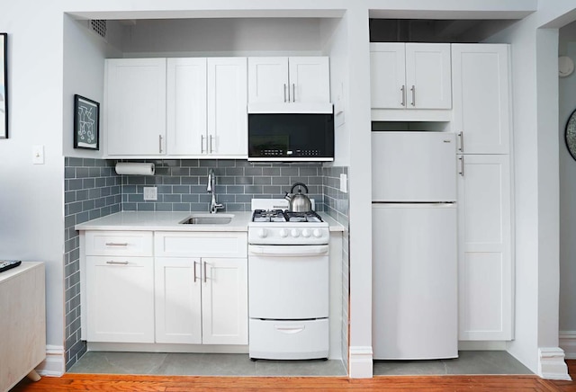 457 W 57th St Unit 911, New York City, NY 10019 - kitchen featuring white appliances, a sink, light countertops, and white cabinets