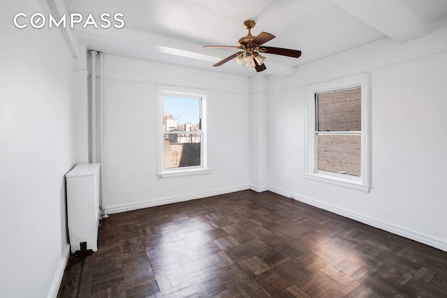 spare room featuring baseboards, radiator heating unit, and a ceiling fan
