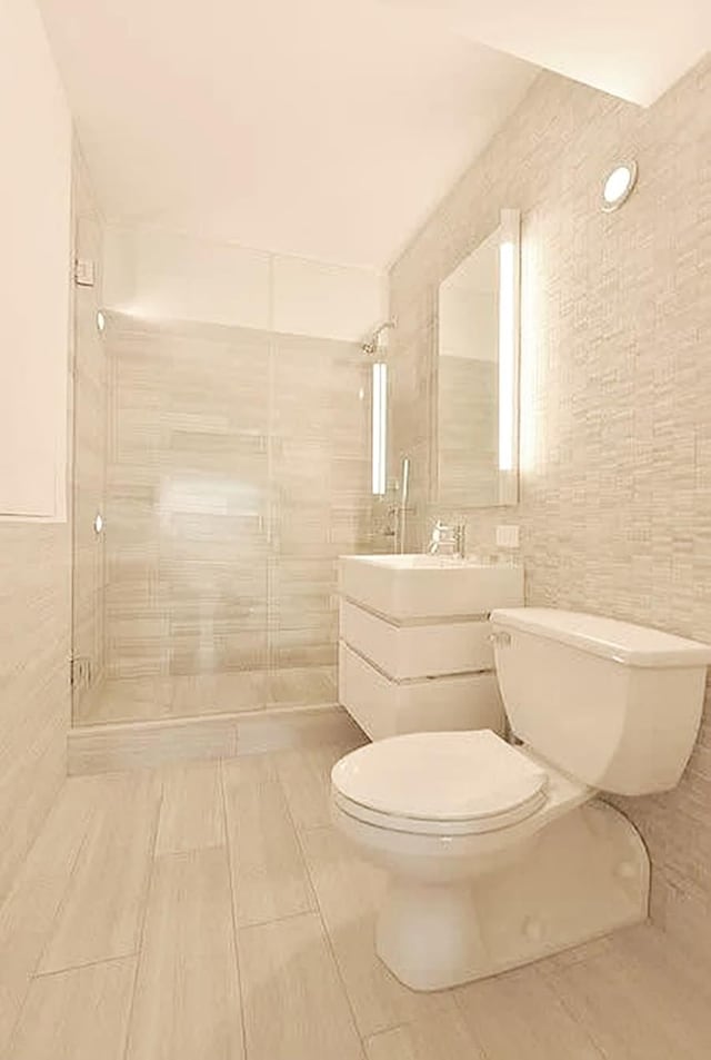 421 Hudson St Unit 305, New York City, NY 10014 - full bath with tile walls, toilet, vanity, and a tile shower